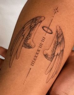 an angel tattoo on the leg of a woman's arm with words and wings