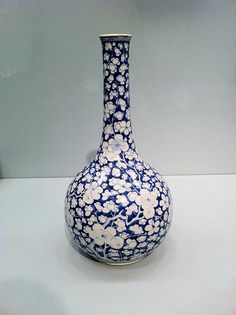 a blue and white vase sitting on top of a table