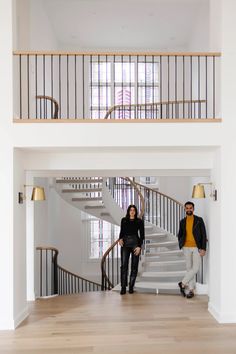 two people standing in front of a stair case