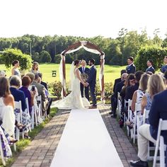 a bride and groom standing at the end of their wedding ceremony