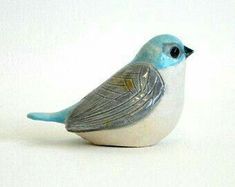 a small blue bird sitting on top of a white table