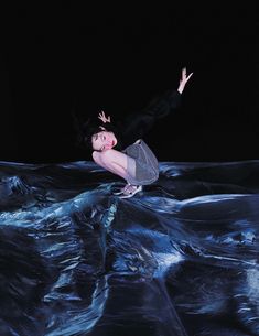 a woman is floating in the water with her arms outstretched and legs spread wide out