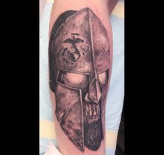 a man's arm with a spartan helmet tattoo on it