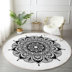 a black and white circular rug with an ornate design on the floor next to a chair