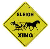 a yellow sign that says sleigh xing with a horse pulling a sleigh