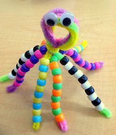 an octopus made out of candy sticks on a wooden table with other items in the background