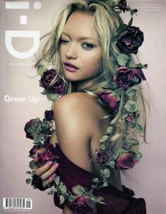 a woman with flowers in her hair and dress on the cover of a magazine,