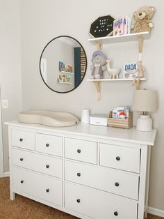 a baby's room with a dresser and mirror