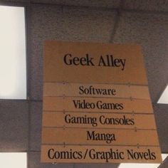 a sign hanging from the side of a building that says geek alley software video games gaming consoles managa comics graphic novels