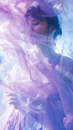 a woman with her hair blowing in the wind, wearing a purple dress and veil