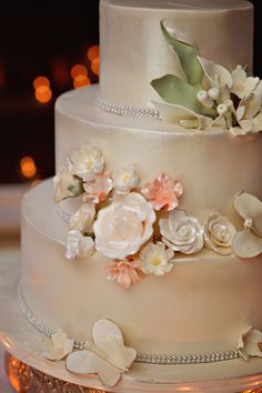 a wedding cake decorated with flowers and pearls