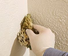 a person is cleaning the wall with a sponge