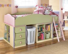 a child's bed with pink and green furniture