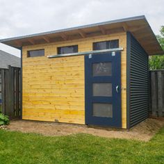 a small wooden shed sitting on top of a lush green field