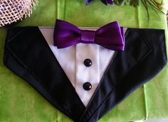 a black tuxedo with a purple bow tie and white shirt is on display