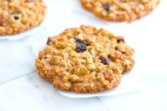 three oatmeal cookies sitting on top of white paper next to each other