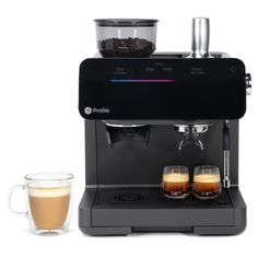 an espresso machine with two glasses next to it