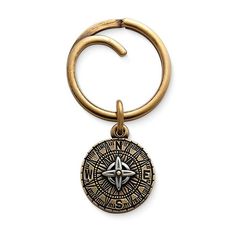 a gold colored keychain with a compass on the front and an open loop around it