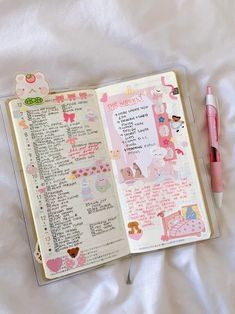 an open notebook with writing on it next to a pink pen and some other items