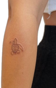 a small turtle tattoo on the arm