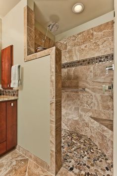 a walk in shower sitting inside of a bathroom next to a sink and counter top