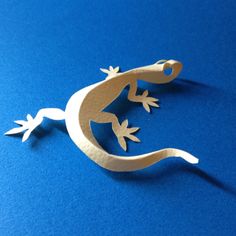 a paper cut out of a lizard on a blue surface