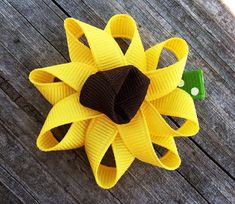 a yellow and brown hair bow on a wooden surface