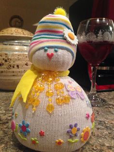 a stuffed animal sitting on top of a counter next to a glass of wine