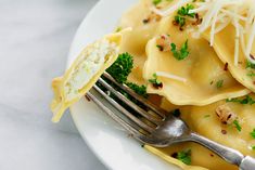 a white plate topped with pasta covered in cheese and parmesan