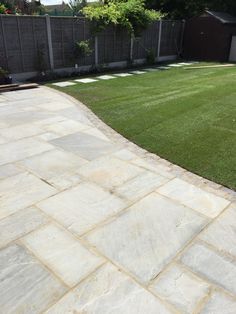 an empty backyard with grass and stone walkway