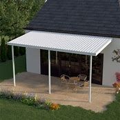 a small white house with a patio and table