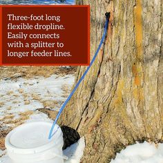 a bucket tied to a tree next to a sign that says, three - foot long flexible dripline easily connects with a spliter to longer feeder lines