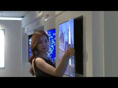 a woman standing in front of two televisions