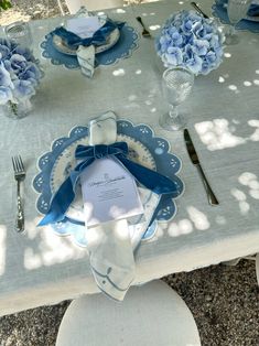 the table is set with blue and white plates, napkins, and silverware