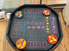 a black tray with buttons on it and the words patterns written in pink, blue, yellow and green