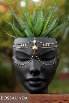 a black mask with a plant in it's head