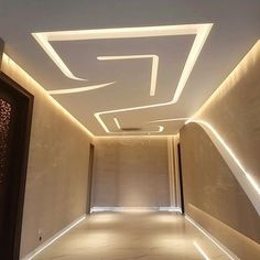 an empty hallway is lit up with white lights and recessed in lighting fixtures on the ceiling