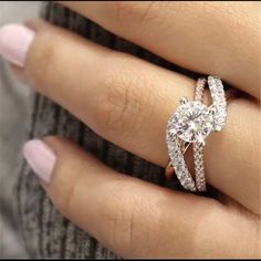 a woman's hand with a diamond ring on top of her finger and an engagement band