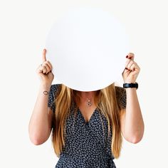 a woman covering her face with a white board