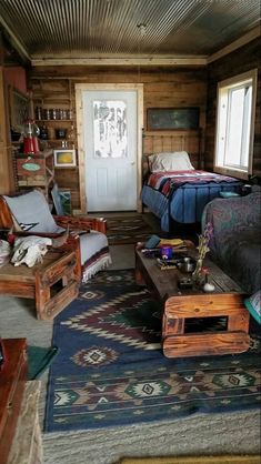 a living room filled with lots of furniture and decor on top of a blue rug