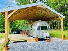 an rv is parked under a wooden carport