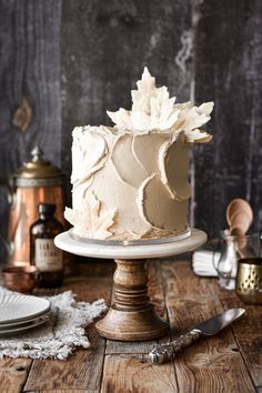 a white frosted cake sitting on top of a wooden table