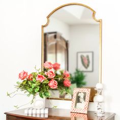 there is a mirror and flowers on the dresser