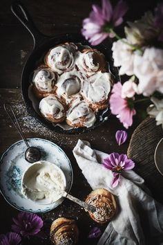 a pan filled with pastries next to purple flowers