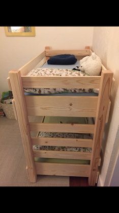 a wooden bunk bed sitting in the corner of a room next to a wall with a stuffed animal on it