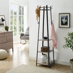 a living room with white walls and wooden floors, an iron rack holds items on the wall