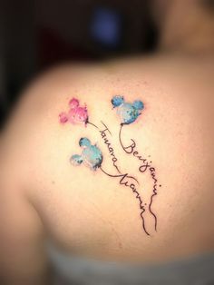 the back of a woman's shoulder with flowers and words written in cursive writing