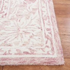 a red and white rug on top of a wooden floor