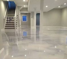 an empty room with white floors and stairs