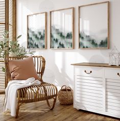 a room with white walls and wooden floors, two framed pictures on the wall above a wicker chair